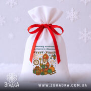 Універсальний дитячий подарунковий мішечок на білому фоні зі сніжинками, червона стрічка, контрастний святковий дизайн.