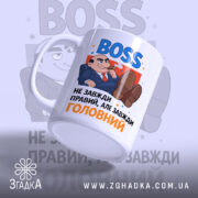 Чашка BOSS для офісу, біла, зображена з бокового ракурсу, фон світло-сірий з розмитими елементами, принт містить напис 'BOSS' синього кольору та карикатуру чоловіка в костюмі, ручка стандартна, край рівний, глянцевий.