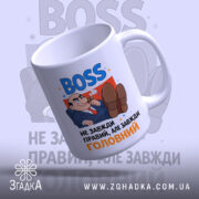 Чашка BOSS для офісу, біла, зображена з верхнього ракурсу, фон світло-сірий з розмитими елементами, принт містить напис 'BOSS' синього кольору та карикатуру чоловіка в костюмі, ручка стандартна, край рівний, глянцевий.