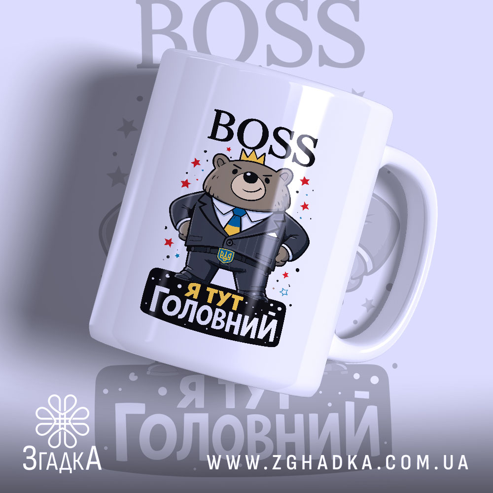 Чашка BOSS я головний, біла з кольоровим принтом, показує ведмедя в костюмі з короною, напис 'Я ТУТ ГОЛОВНИЙ' на чорному фоні, ручка гладка, край рівний, глянцева поверхня.