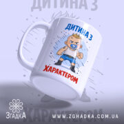 Чашка дитина з характером, біла, зображення з правого боку, фон світло-сірий, принт з малюнком хлопчика з пустушкою, напис 'ДИТИНА З ХАРАКТЕРОМ' у верхній частині, ручка звичайна, край рівний, глянцевий.