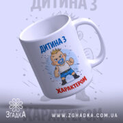 Чашка дитина з характером, біла, зображення з правого боку, фон світло-сірий, принт з малюнком хлопчика з пустушкою, напис 'ДИТИНА З ХАРАКТЕРОМ' у верхній частині, ручка звичайна, край рівний, глянцевий.