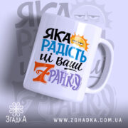 Чашка яка радість зранку, біла, з кольоровим принтом, на фоні з легким градієнтом, з написом 'ЯКА РАДІСТЬ' у блакитному та чорному кольорах, з жовтим сонцем, ручка стандартна, край рівний, глянцевий.