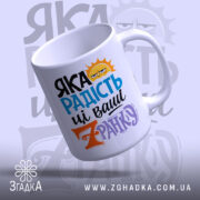 Чашка яка радість зранку, біла, з кольоровим принтом, на фоні з легким градієнтом, з написом 'ЯКА РАДІСТЬ' у блакитному та чорному кольорах, з жовтим сонцем, ручка стандартна, край рівний, глянцевий, з видимим верхом.