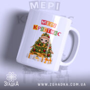 Чашка Магічний час Різдва, біла, з ракурсом зліва, фон світло-фіолетовий, принт з ведмедиком на ялинці та написом 'МЕРІ КРІСТМАС', ручка округла, край гладкий, глянцевий.