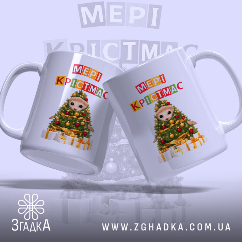 Чашка Магічний час Різдва, біла, з ракурсом зліва, фон світло-фіолетовий, дві чашки з принтом ведмедика на ялинці та написом 'МЕРІ КРІСТМАС', ручки округлі, краї гладкі, глянцеві.