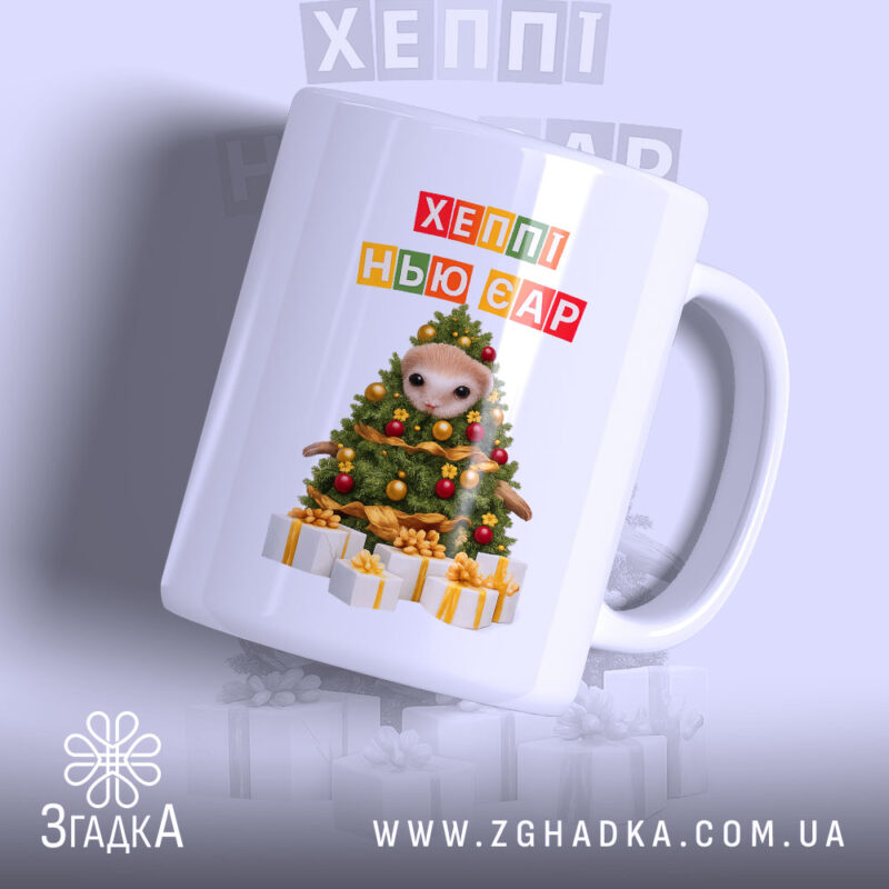 Чашка новорічна казка з подарунками, біла, з прямим ракурсом, на фоні світло-сірого кольору, принт з новорічною ялинкою та написом 'ХЕППІ НЬЮ ЄР', ручка округла, край гладкий, глянцева поверхня.