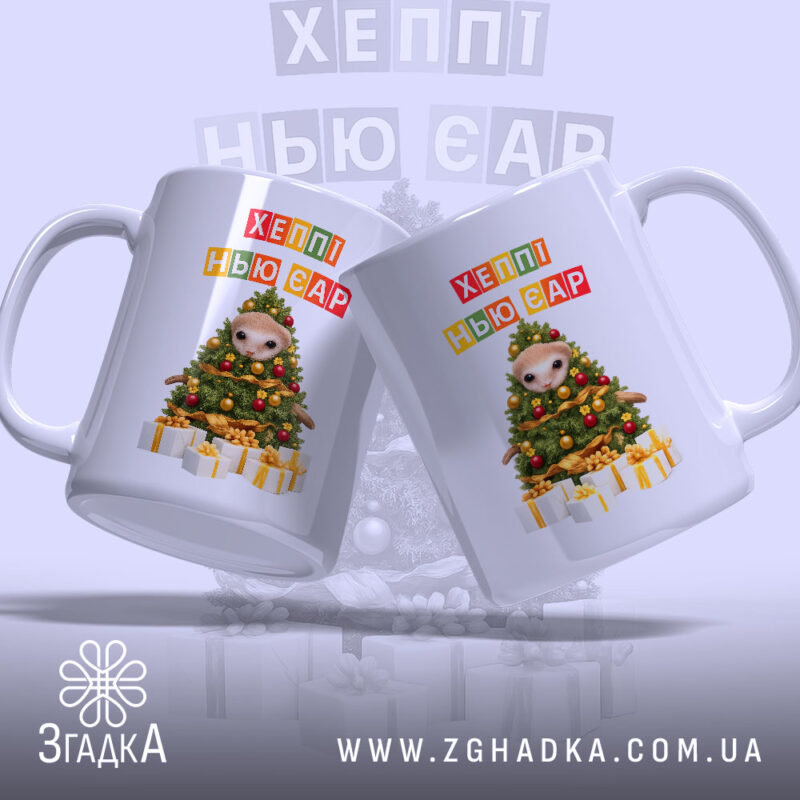 Чашка новорічна казка з подарунками, біла, з двома чашками в ракурсі, на фоні світло-сірого кольору, принт з новорічною ялинкою та написом 'ХЕППІ НЬЮ ЄР', ручки округлі, краю гладкі, глянцева поверхня.