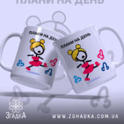 Чашка плани на день, дві білих чашки з кольоровим принтом, зображення дівчини в червоній спідниці, ручки з обох боків, край рівний, матова поверхня, фон світло-сірий.