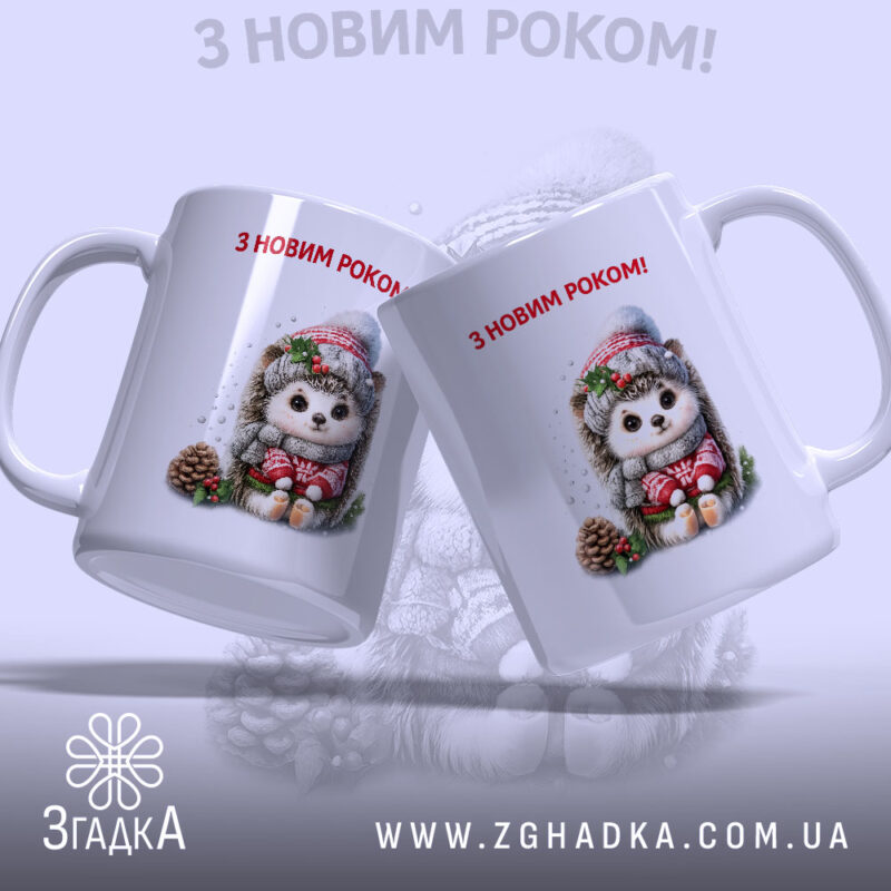 Чашка Подарунок на свята. Дві білосніжні чашки, що стоять поруч, з однаковим малюнком їжачка у святковому одязі. Ручки класичної форми, краї рівні, глянцеві. Напис 'З НОВИМ РОКОМ!' червоного кольору на обох чашках.