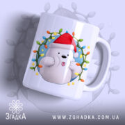 Чашка Веселий новорічний ведмедик, біла з яскравим принтом ведмедика у червоній шапці, ракурс з боку, фон з м'яким світлом, принт обрамлений різнокольоровими вогниками, ручка стандартна, край рівний, глянцева поверхня.