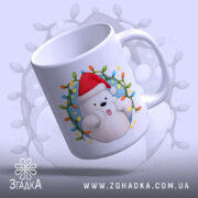 Чашка Веселий новорічний ведмедик, біла з яскравим принтом ведмедика у червоній шапці, ракурс зверху, фон з м'яким світлом, принт обрамлений різнокольоровими вогниками, ручка стандартна, край рівний, глянцева поверхня.