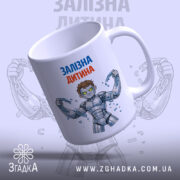 Чашка залізна дитина, біла з кольоровим принтом, на якій зображено персонажа з коротким волоссям у сірому костюмі, що тримає ланцюги. Ручка гладка, край рівний, поверхня має глянець, фон світло-сірий з розмитим зображенням.