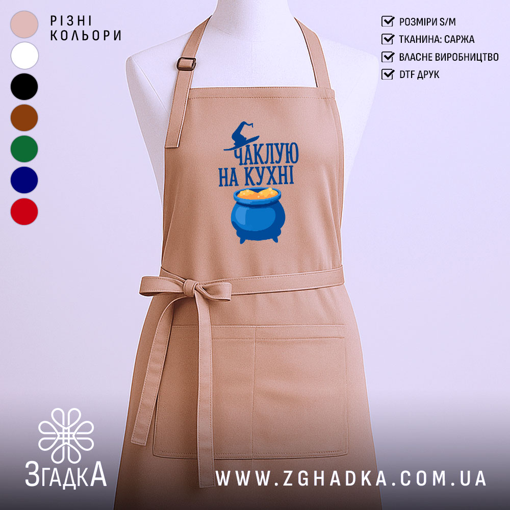 Fartukh Chakluiu Na Kukhni Stylnyi Aksesuar Dlia Kukhni 1 Фартух чаклую на кухні, бежевого кольору, зображений з фронтального ракурсу на манекені, фон нейтральний, принт з написом та зображенням казана з варивом.