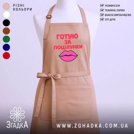 Фартух готую за поцілунки, бежевого кольору, зображений з фронтального ракурсу на манекені, фон світлий, принт з текстом червоного кольору та малюнком губ рожевого кольору.