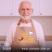 Фартух моя кухня, бежевий колір, зображення з верхнього ракурсу, фон дерев'яний, принт з написом 'Моя кухня Мої правила' та зображенням шеф-капелюха і вогню.