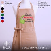 Фартух найкраща господиня, бежевого кольору, зображений з переднього ракурсу на манекені, фон світлий, принт з написом "Ось так виглядає Найкраща у світі господиня" та малюнком каструлі.