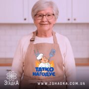 Фартух татко всіх нагодує. Фартух бежевого кольору, зображений з фронтального ракурсу на манекені. Фон світлий, без зайвих деталей. Принт містить малюнок кухаря з лопаткою та виделкою, а також напис 'ТАТКО ВСІХ НАГОДУЄ' у яскравих кольорах.