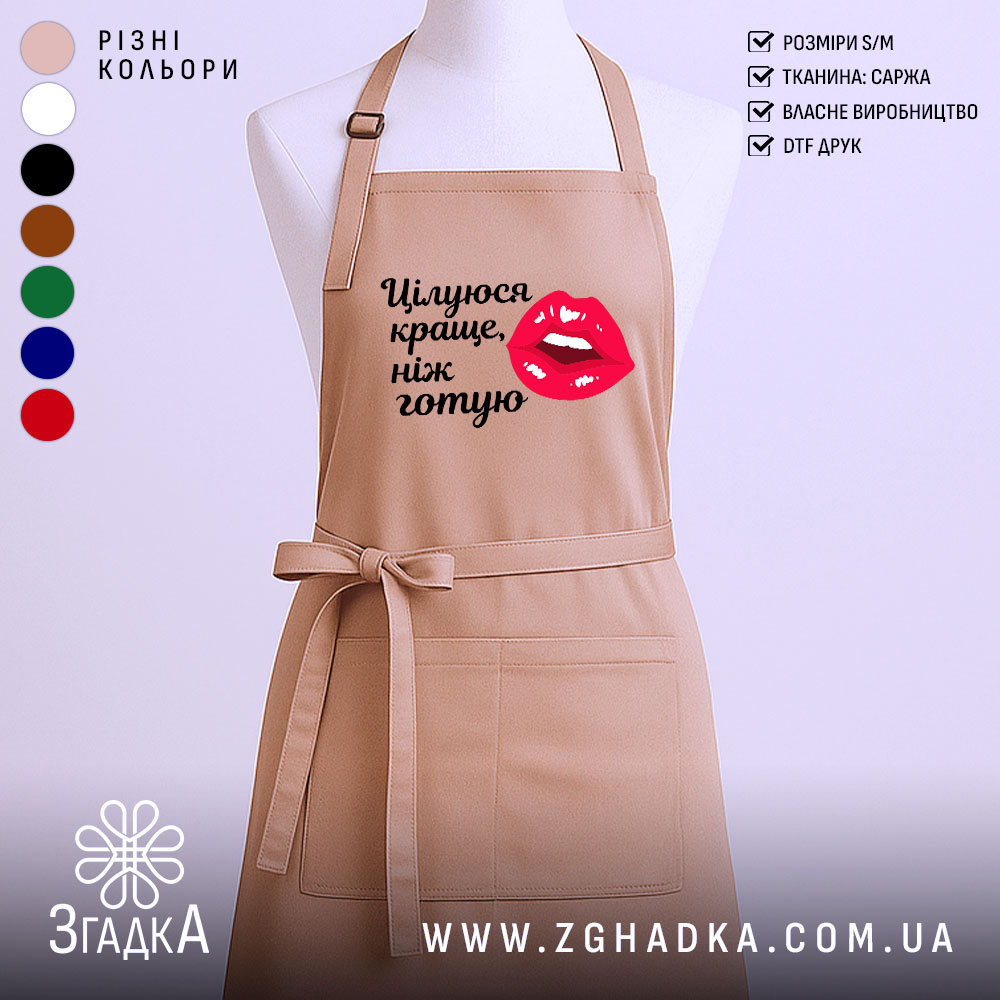 Fartukh Tsiluiusia Krashche Nizh Hotuiu Stylnyi Aksesuar Dlia Kukhni 1 Фартух цілуюся краще ніж готую, бежевого кольору, зображений з фронтального ракурсу на манекені, фон однотонний, принт з червоними губами та текстом чорного кольору.