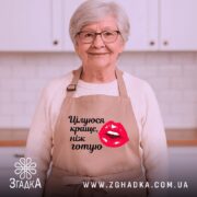 Фартух цілуюся краще ніж готую, бежевого кольору, зображений з фронтального ракурсу на манекені, фон однотонний, принт з червоними губами та текстом чорного кольору.