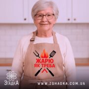 Фартух жарю як треба, бежевого кольору, зображений на манекені з ракурсу спереду, фон світлий, принт з червоним текстом та графічними елементами у вигляді вогню та кухонних інструментів.