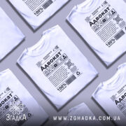 Футболка адвокат білого кольору, зображена з правого боку на манекені, фон нейтральний, принт містить текст та символи, що відображають професію адвоката.