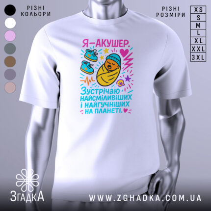 Футболка акушер, біла, зображена на манекені, фон світло-сірий, принт з мультяшним малюнком немовляти в ковдрі, з червоним серцем та кольоровими елементами.