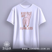 Футболка альпака гумор, біла, підвішена на вішалці, фон світло-сірий, принт з альпакою та написом 'KISS MY ALPACASS' у рожевих тонах.