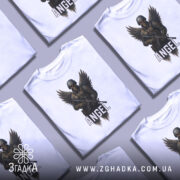 Футболка ангел боєць білого кольору, зображена на манекені, фон світло-сірий, принт з зображенням ангела-борця з крилами та автоматом, напис 'ANGEL' під малюнком.