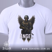 Футболка ангел боєць білого кольору, складена на столі, фон світло-сірий, принт з зображенням ангела-борця з крилами та автоматом, напис 'ANGEL' під малюнком, на футболці є етикетка з зеленим шнурком.