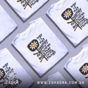 Футболка антивоєнна позиція, біла, зображена на манекені, фон світло-сірий, принт з жовтою квіткою та текстом чорного кольору.