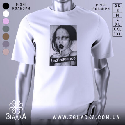 Футболка bad influence білого кольору, зображена на манекені з металевим блиском, фон нейтральний, принт з дівчиною, що тримає льодяник, з текстом 'bad influence' на чорному фоні.
