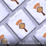 Футболка Бариста білого кольору, зображена з близького ракурсу, на манекені. Принт на футболці містить текст 'BARISTAS NOT BUTTON PUSHERS' та зображення портафільтра, виконаного в коричневих тонах.