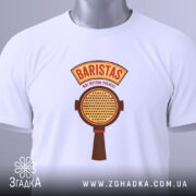 Футболка Бариста білого кольору, складена на поверхні, з видимим принтом. Принт містить текст 'BARISTAS NOT BUTTON PUSHERS' та зображення портафільтра, на футболці підвішена етикетка з зеленим шнурком.