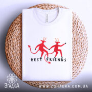 Футболка бесті друзі демони, біла, складена на плетеній кошику, фон світло-сірий, принт з двома червоними демонами, які тримаються за руки, текст 'BEST FRIENDS' під ними.