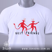 Футболка бесті друзі демони, біла, складена на столі, фон світло-сірий, принт з двома червоними демонами, які тримаються за руки, текст 'BEST FRIENDS' під ними, на футболці є етикетка.
