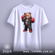 Футболка боксерський ведмідь, біла, підвішена на вішалці, фон світло-сірий, принт ведмедя в боксерських рукавичках та шкіряному жакеті, з червоними черевиками.