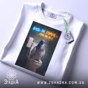 Футболка будь як голуб, білого кольору, з верхнього ракурсу, на фоні світло-сірого градієнту, з принтом, що зображує голуба на унітазі, з написом 'БУДЬ ЯК ГОЛУБ - СРИ НА ВСЕ' у неоновому стилі, з етикеткою на зеленій стрічці.