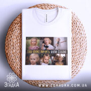 Футболка будь собою завжди. Біла футболка, складена на плетеній основі, з принтом, що демонструє дітей у різних ситуаціях. Фон натуральний, акцент на принті та текстурі основи.