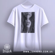 Футболка бунтарський арт, біла, підвішена на вішалці, фон світло-сірий, принт у чорному та білому кольорах з дівчиною, що показує середній палець з написом 'FUCK YOU' на руці.