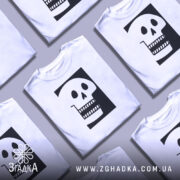 Футболка череп білого кольору, зображена з правого ракурсу на манекені, фон світло-сірий, принт чорного кольору з малюнком черепа, що має великі очі та зуби.