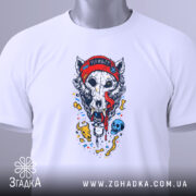 Футболка Череп Вовка, біла, складена на столі, фон світло-сірий, принт з черепом вовка у червоній шапці, з язиком, що стікає, з елементами в кольорі.