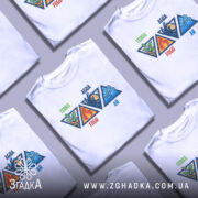 Футболка чотири стихії, біла, зображена з фронтального ракурсу на манекені, фон світло-сірий, принт містить чотири трикутники з символами стихій: зелений листок для Землі, червоний вогонь для Вогню, синя хвиля для Води та блакитний вітер для Повітря.