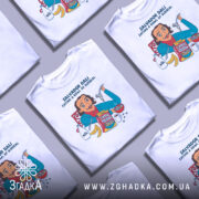 Футболка Далі арт принт, біла, зображена на манекені, фон світло-сірий, принт з ілюстрацією Сальвадора Далі, який їсть з миски, з деталями молока, бананів і коробки з написом 'Surreal'.