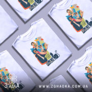 Футболка Далі арт, біла, зображена на манекені, фон світло-сірий, принт з обличчям художника, кольорові деталі, текст "I don't do drugs I AM drugs" та чорна кішка.