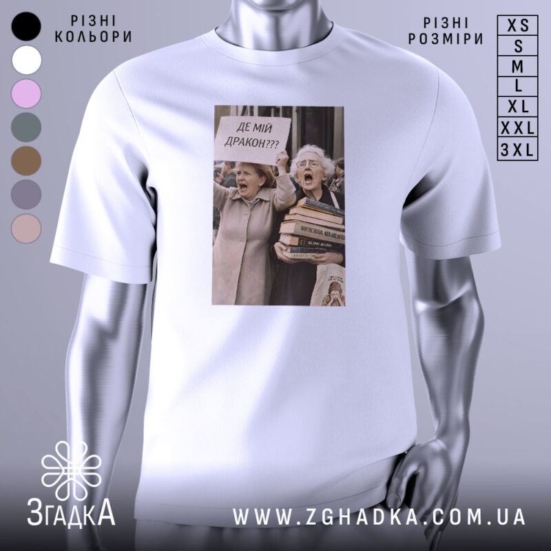 Футболка де мій дракон, біла, зображена з правого ракурсу, на фоні світло-сірого кольору, принт з двома жінками, які тримають плакат з написом 'ДЕ МІЙ ДРАКОН???' та купою книг.