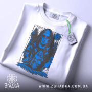 Футболка демонічна ніч, складена футболка на білому фоні, принт з темною фігурою та червоними очима, деталі принта чітко видимі, на футболці є етикетка з зеленим шнурком.