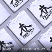 Футболка друзі не брешуть, біла, зображена з фронтального ракурсу на манекені, фон світло-сірий, принт чорного кольору з силуетом людини та великими руками.