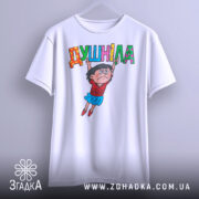 Футболка душніла білого кольору, підвішена на вішалці, з принтом, що зображає персонажа, який тримає напис "Душніла". Фон світлий, деталі принта яскраві.