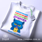 Футболка душніла експерт, біла футболка з принтом, зображення кота з блакитною шерстю, що тримає жовту чашку, текст на футболці кольоровий: синій, зелений, фіолетовий, червоний, вид з близька, на футболці є етикетка.